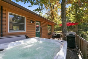 A wooden cabin with a hot tub, a deck, and a red umbrella. - Private Home on 3 Acres! 5 Bedrooms - Private Hot Tub - Close to Strip! | Silver Creek (Branson)