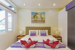 Habitación de hotel con una cama grande, dos mesitas de noche, un cuadro en la pared y una ventana con persianas.
