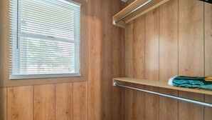 Un interior de madera con una ventana, una repisa metálica y una barra de metal.