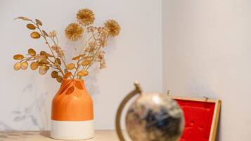 A vase with dried flowers and a globe on a table.