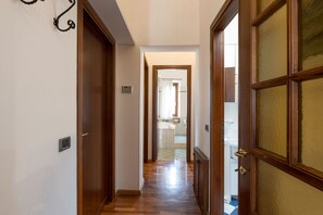 A hallway with wooden doors and a checkered floor leading to a bathroom. - Casa Miramonti in Perugia (Perugia)