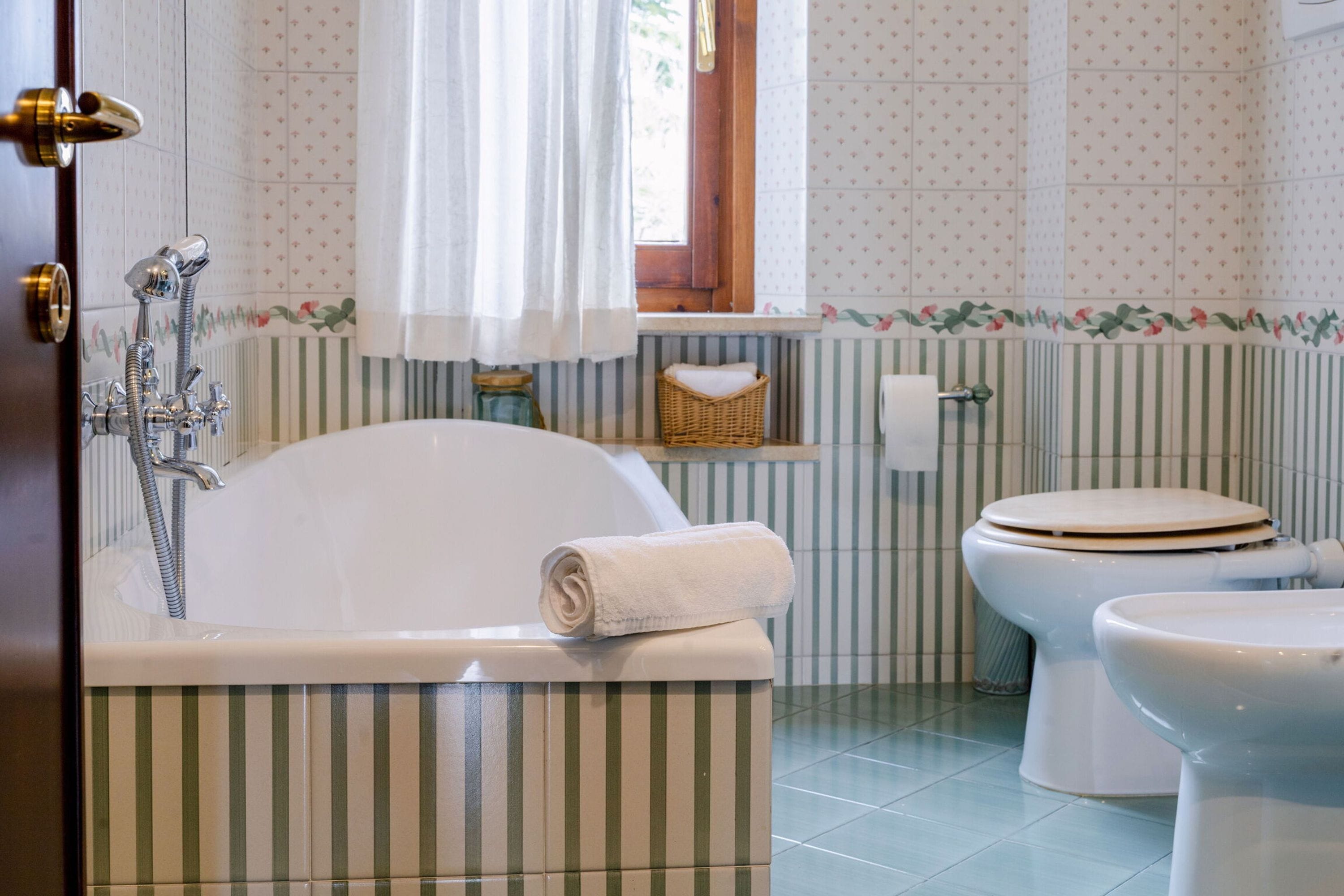 Ein Badezimmer mit Badewanne, Toilette und Dusche.