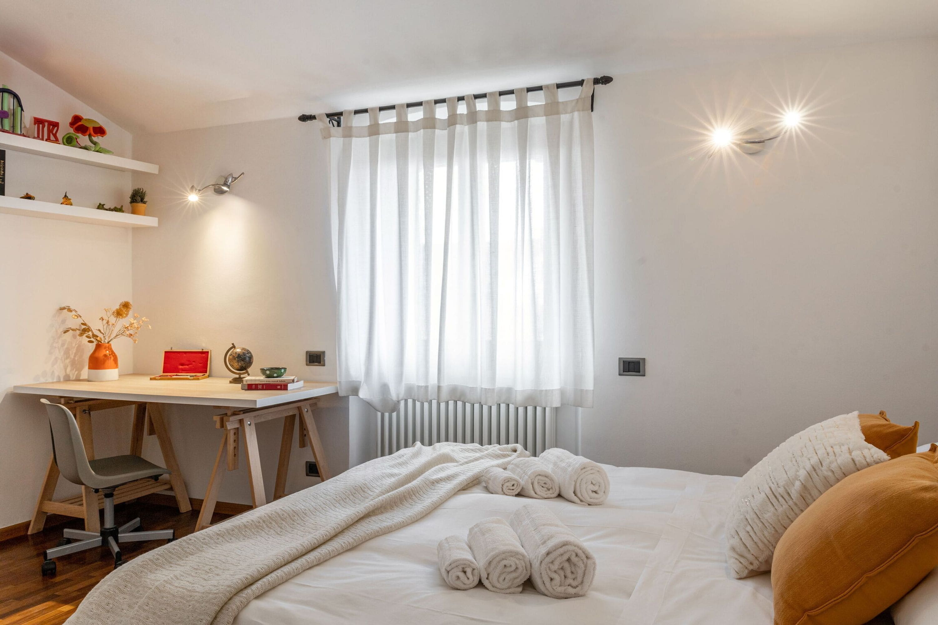 Un dormitorio con cama, escritorio y radiador.