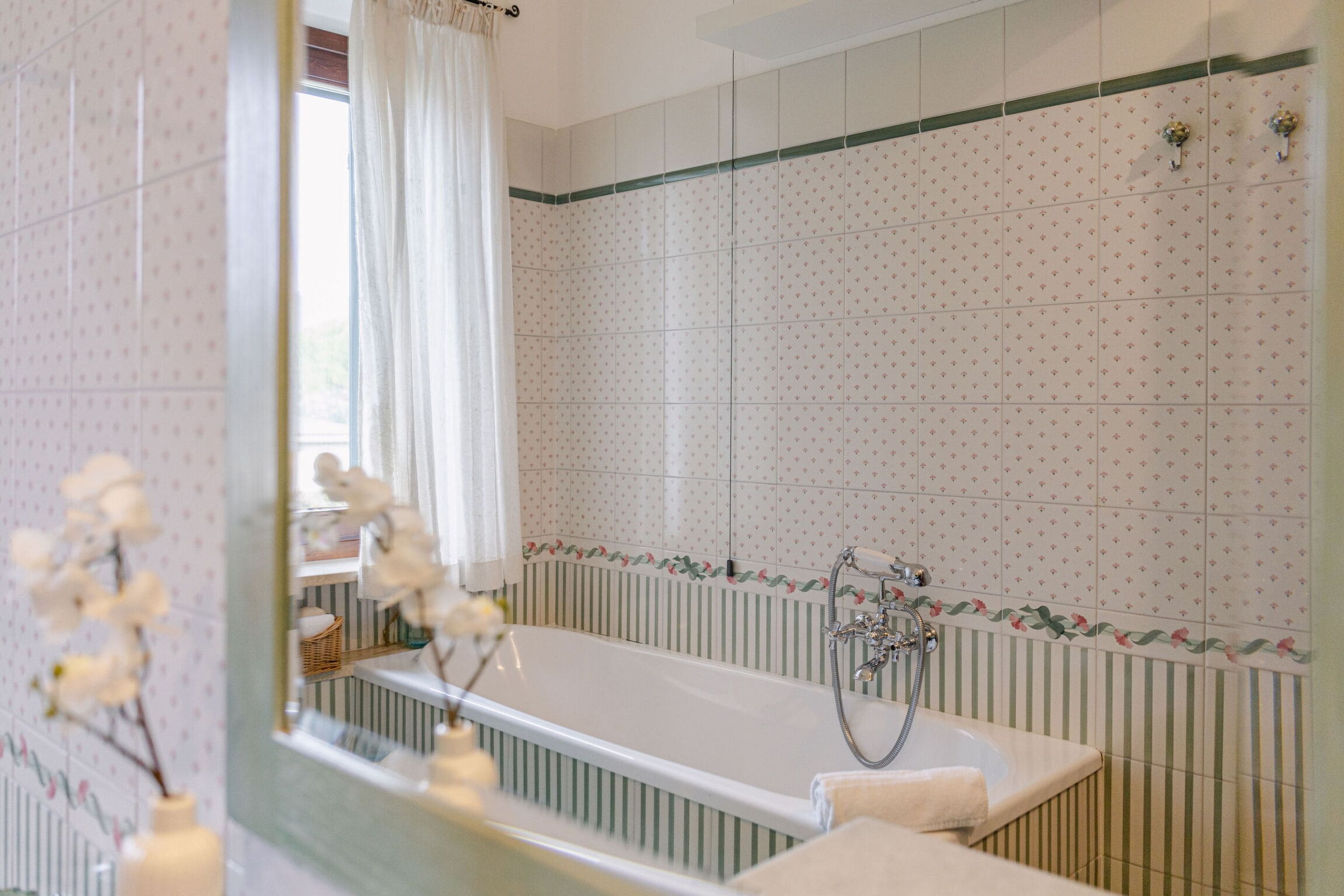 Un baño con bañera, ducha y espejo.