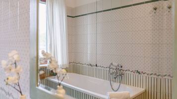 Un baño con bañera, ducha y espejo.