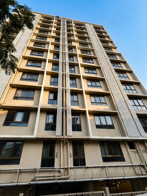 Un immeuble de grande hauteur doté d’une façade symétrique, de nombreuses fenêtres et d’un élément structurel vertical central.