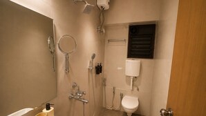 Casa de banho compacta com chuveiro, sanita e lavatório.