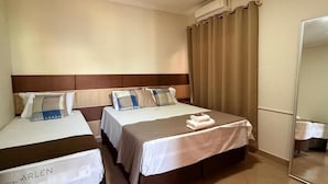Ein Hotelzimmer mit zwei Betten, einem Spiegel und einem Vorhang.