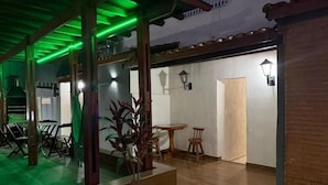 Um espaço interno com área de refeições, um vaso de planta e uma porta que dá para outro cômodo.