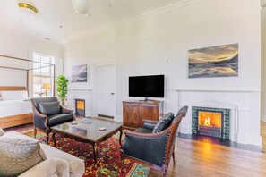 Amplia sala de estar con chimenea, televisor y un cuadro grande en la pared.