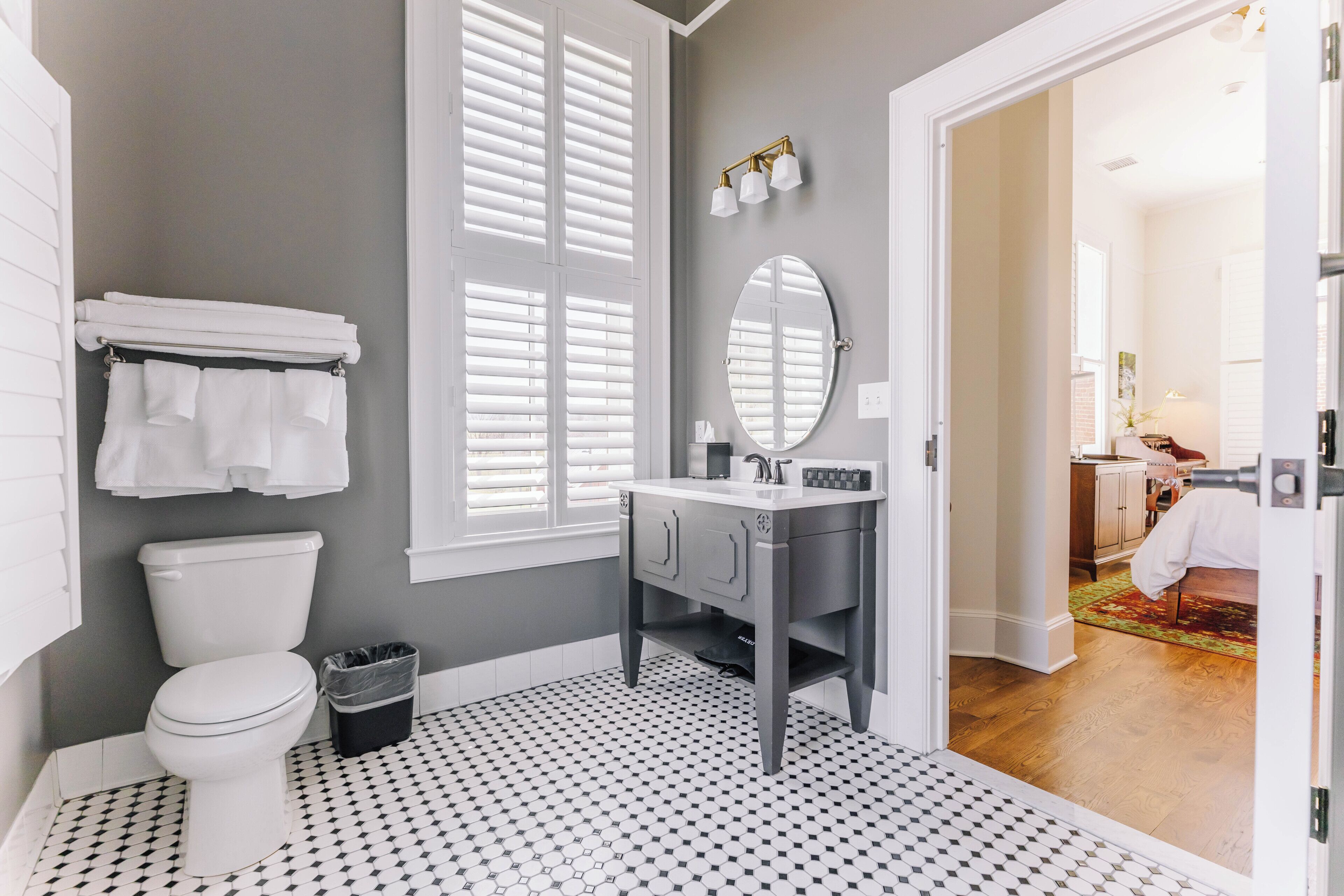 A bathroom with a toilet, a sink, and a mirror.