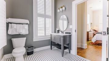 A bathroom with a toilet, a sink, and a mirror.