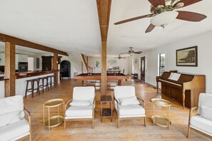 A spacious living area with a pool table, white sofas, a piano, and a ceiling fan. - 5-acre Historic Home With Pool Fishing Pond Game Room Outdoor Bar (Augusta)