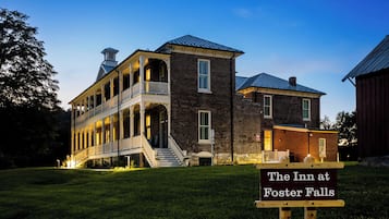 A historic building with a two-story porch and a brick section, labeled as 'The Inn at Foster Falls.'