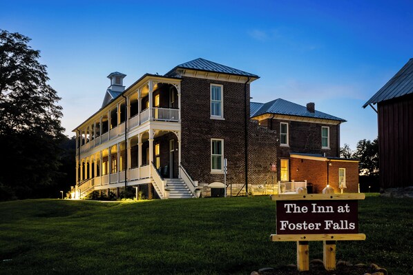A historic building with a two-story porch and a brick section, labeled as 'The Inn at Foster Falls.'