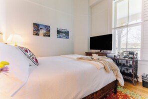 A hotel room with a bed, a TV, a coffee machine, and artwork on the wall. - Historic Queen Room by New River Trail (Max Meadows)