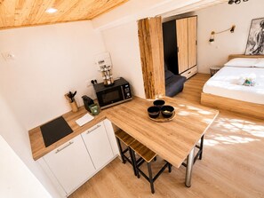 Una cocina compacta con microondas, cafetera y un mueble pequeño.