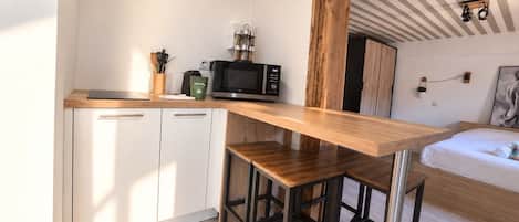 A compact kitchen with a wooden countertop, a microwave, and a coffee maker.