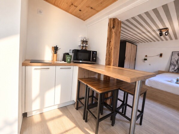 A compact kitchen with a wooden countertop, a microwave, and a coffee maker.