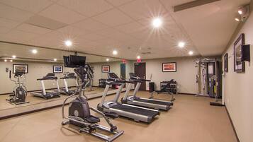 A gym with treadmills, elliptical machines, and weight equipment.