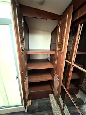 A walk-in closet with multiple shelves and a door.