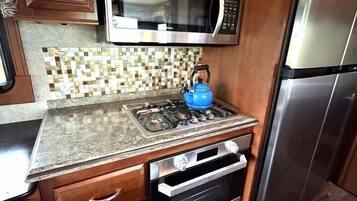 Cocina compacta con microondas, horno y refrigerador.