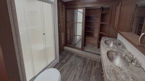 A bathroom with a skylight, a walk-in closet, and a double sink vanity. - Bozeman Basecamp | Luxury RV 11 min from BZN (Belgrade)