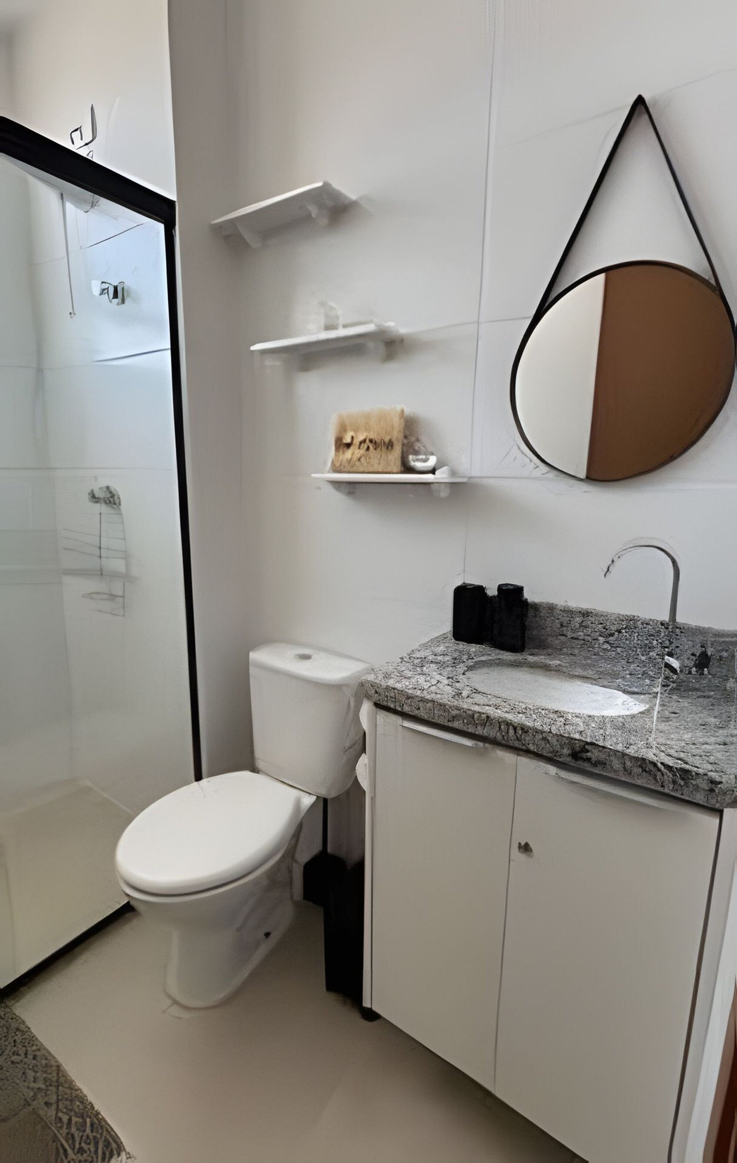 A modern bathroom with a toilet, sink, and shower.