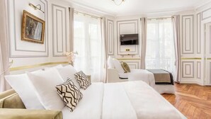 Habitació d'hotel amb un llit gran, una televisió i zona de seients.