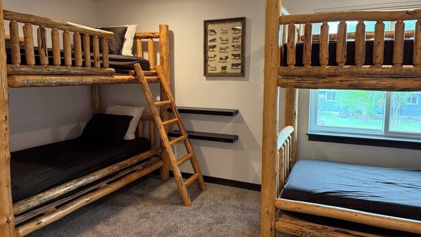 A bunk bed room with a ladder, a framed animal picture, and a window. - 4 Min to Airport • Family Retreat Sleeps 10 (Belgrade)