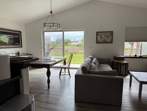 Una sala de estar moderna con sofá, mesa de comedor y sillas.