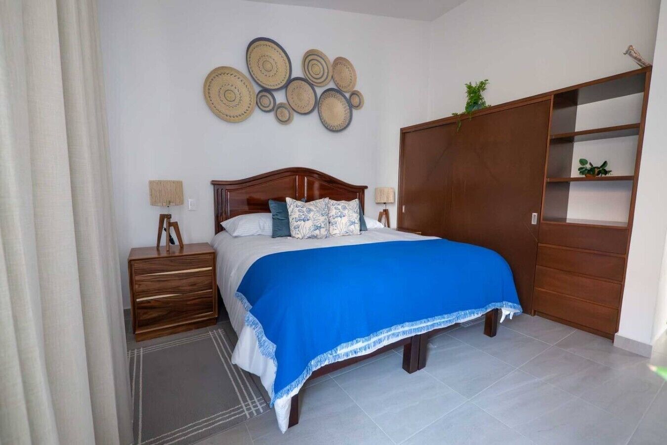 A bedroom with a bed, bedside tables, a wardrobe, and wall decor.