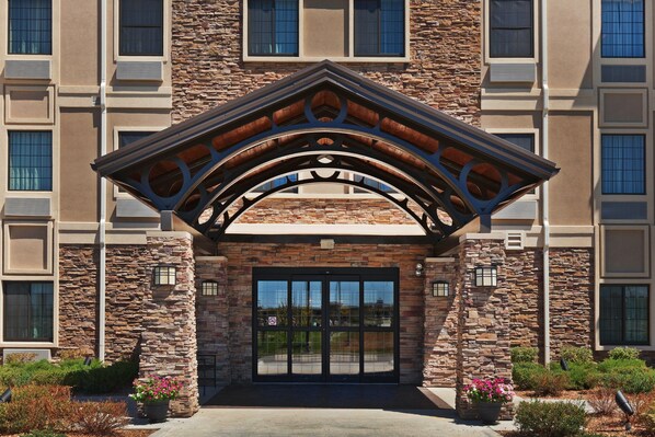 Covered entrance with stone archway and porte-cochere — drop-off and self-park are both available on-site