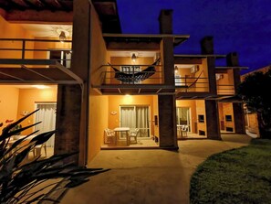 A modern two-story building with a balcony and a dining area. - COSTA ALLEGRA INGLESES RESIDENCE (Florianópolis)