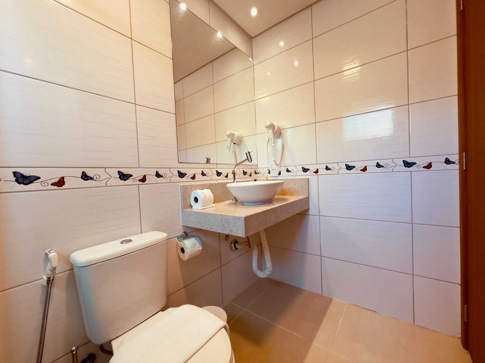 A bathroom with a toilet, sink, and shower.