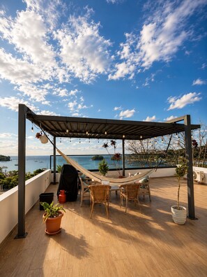 A rooftop terrace with a hammock, wicker furniture, and potted plants. - LEVEL 2, Lovely 2-bedroom apartment with AC steps to malecon in Santa Barbara (Santa Barbara)
