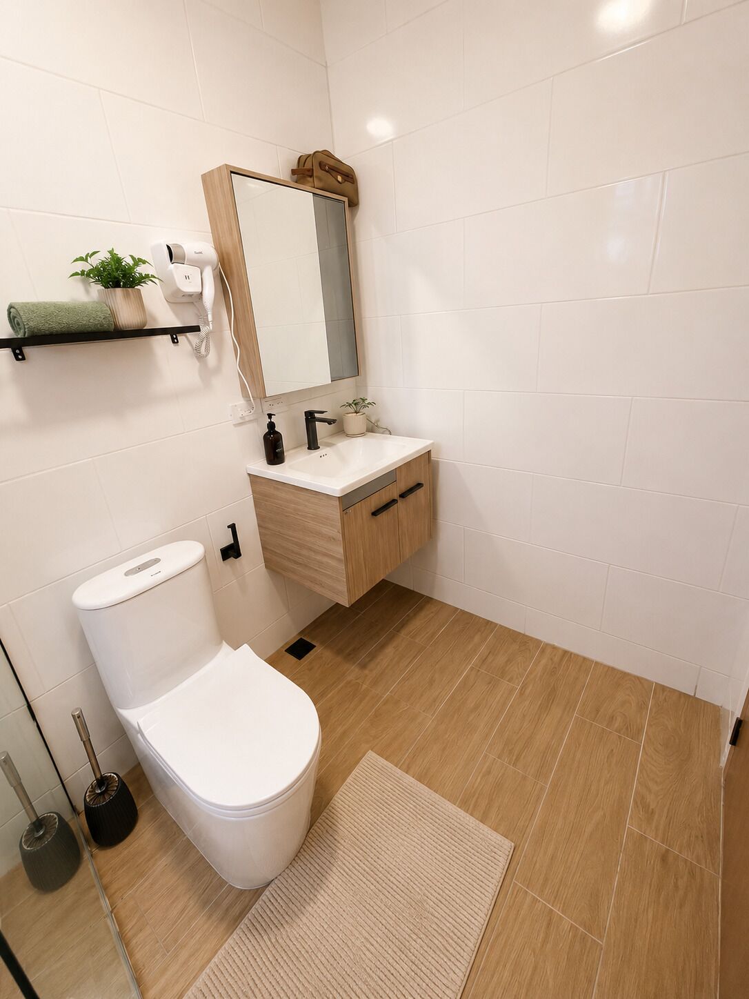 A modern bathroom with a toilet, sink, and mirror.