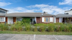A row of single-story houses with a flat roof, a small front yard, and a clear sky. - Ti Kaz Romance, calm and relaxation (Sainte-Suzanne)
