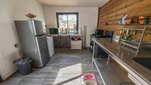 A compact kitchen with a refrigerator, microwave, and wooden cabinets. - Ti Kaz Romance, calm and relaxation (Sainte-Suzanne)