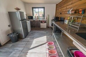 Una cocina compacta con refrigerador, microondas y armarios de madera.