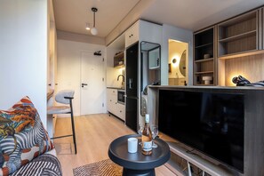 Ein modernes Wohnzimmer mit einer Couch, einem Couchtisch und einem Flachbildfernseher.