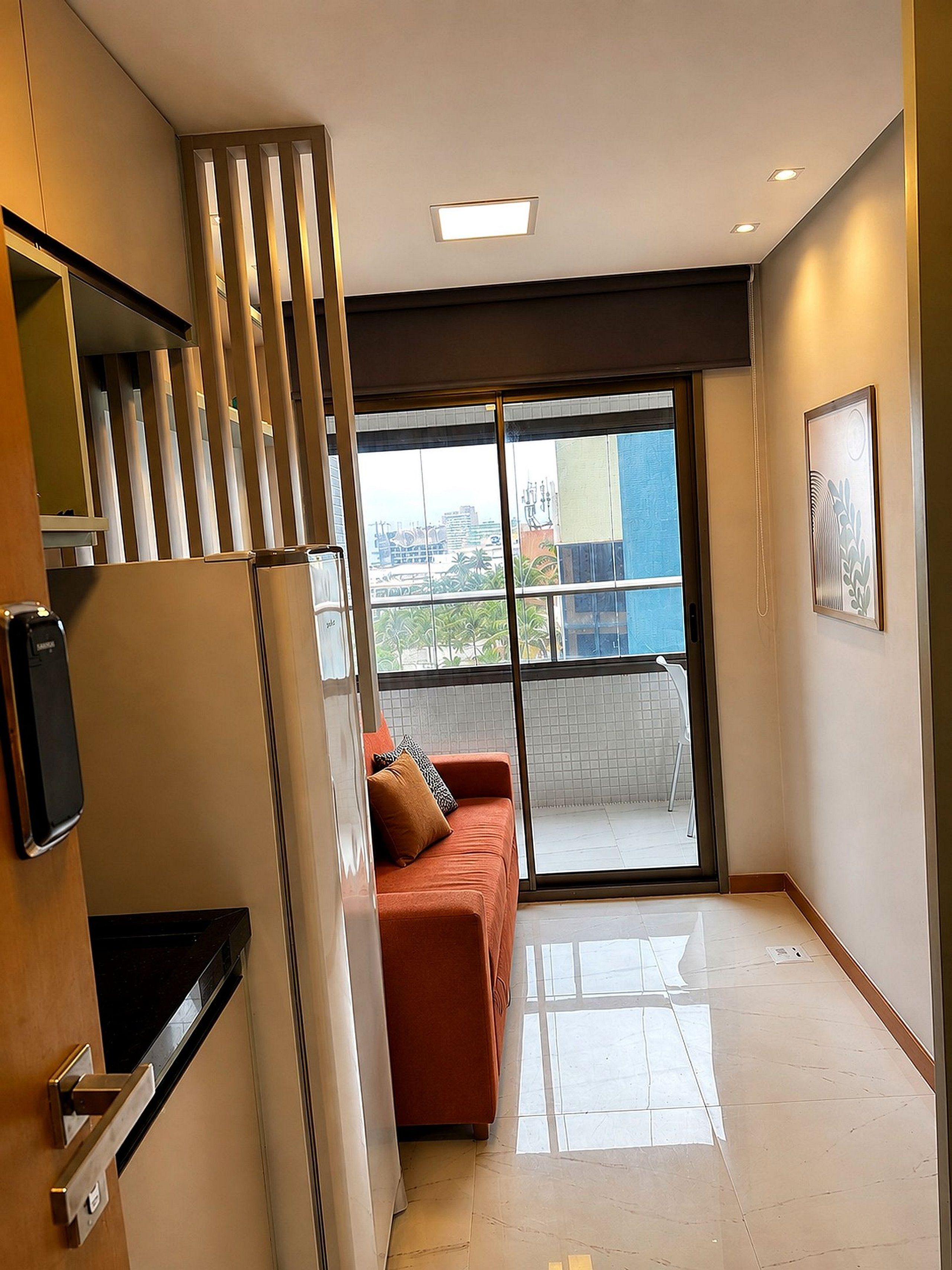 A modern interior with a sofa, a staircase, and a large window offering a view of the cityscape.