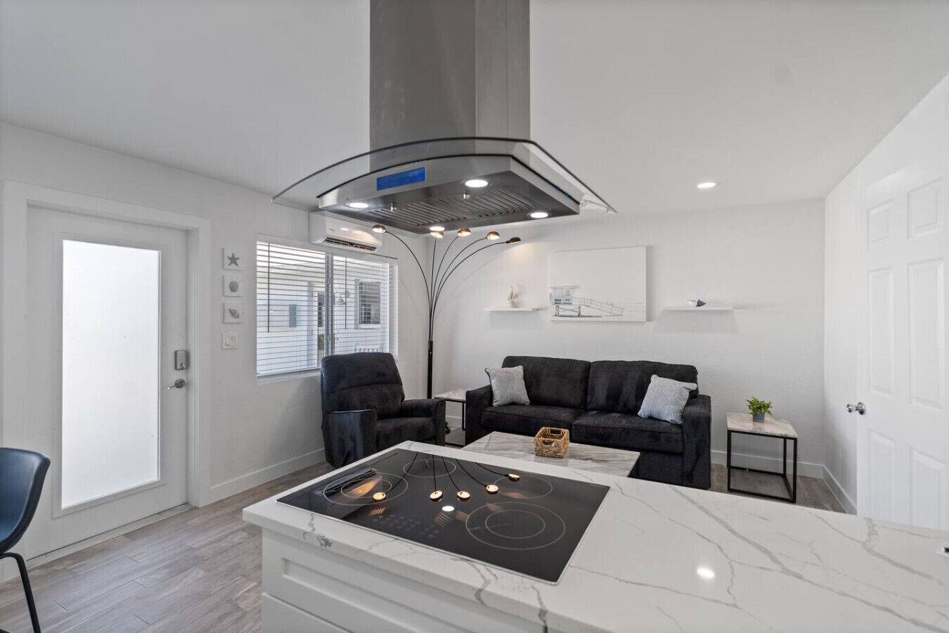 Een moderne keuken met een inbouwfornuis, een zwarte bank en een eettafel.