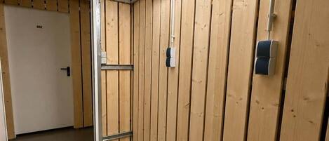 Una habitación con paneles de madera, una puerta y una escalera de metal.