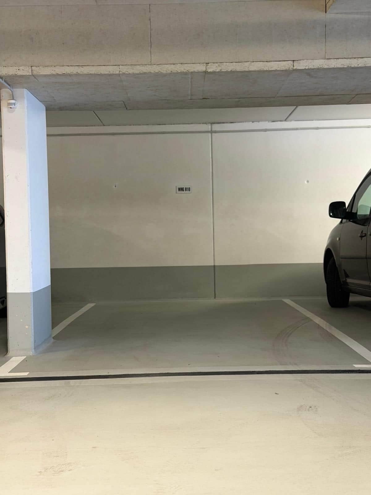 A parking garage with a car parked in a spot marked 'WGS 10'.