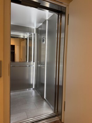 A modern elevator with metallic finish and a control panel. - Erlenhof Vacation Rental - Modern Penthouse in Monschau (Monschau)