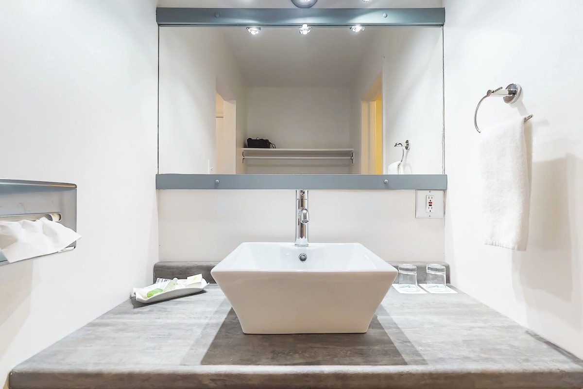A bathroom with a white sink, a towel rack, and a mirror.