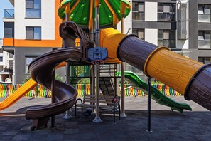 Ein Spielplatz mit Basketballkorb und Rutschen.