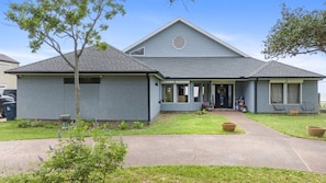 A two-story house with a front porch, a garage, and a well-maintained lawn. - Bayfront 3/2/Loft with pool on Copano Bay with pier (Rockport)