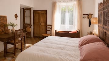Un dormitorio con una cama grande, muebles de madera, un ventanal con cortinas y una pared con paneles decorativos.